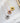 Rose gold, gold and silver necklaces are lined up on a white cloth
