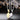 There are halves of the necklace suspended from above on a black background. One is gold, the other is silver.