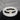 On a white round table, there are black lava and white stone bracelets on top of each other.