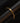 There is a gold colored curb chain on a black tube-shaped object.