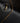 There is a gold colored curb chain on a black background.