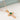 Sterling silver rose gold cross necklaces with emerald green birthstones displayed on a white background.