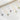 Five birthstone halo necklaces with round-cut crystals in gold and silver chains, displayed on soft white fabric – showcasing sapphire, turquoise, ruby, blue topaz, and emerald pendants.