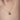 Woman wearing an emerald halo necklace over a white open-collar shirt – elegant and minimal look for everyday style.